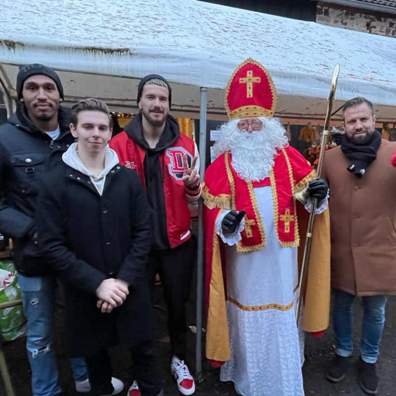 Der Nikolaus lässt sich mit einer Gruppe junger Männer fotografieren. Die Stimmung ist gut.