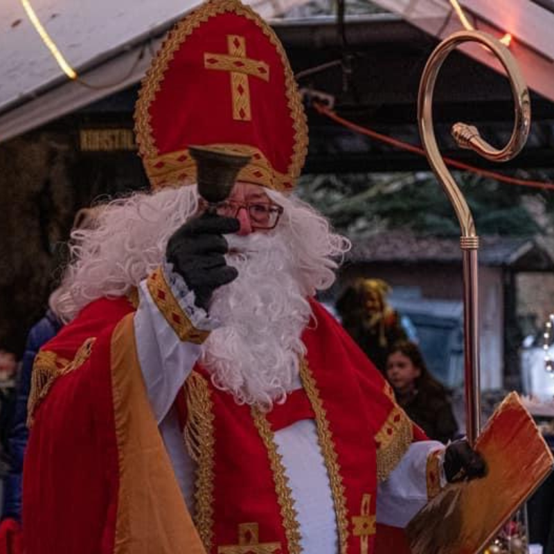 Der Nikolaus läutet seine Glocke. Er hält den Bischhofsstab und das goldene Buch in der Hand. Gleich gibt es Geschenke.