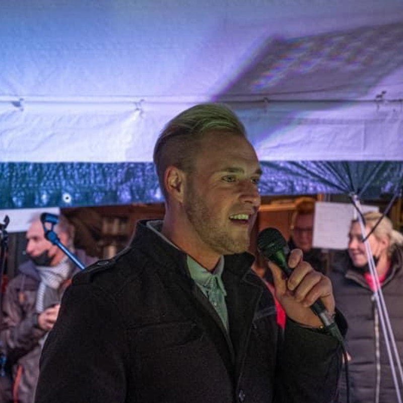 Daniel Ferber begleitet musikalisch den Weihnachtsmarkt. Er stand unter einem Zelt mit Mikrofon in der Hand.